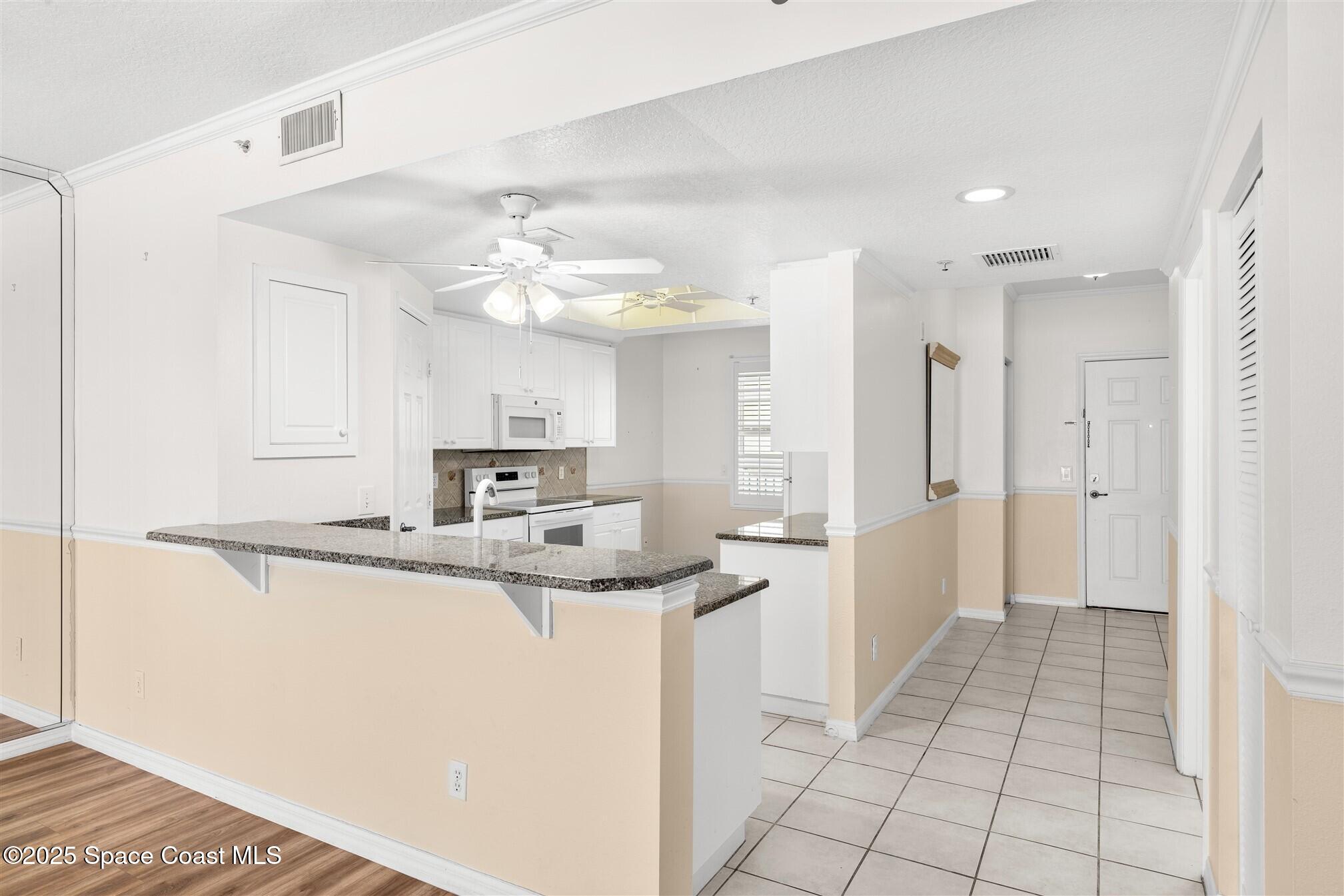 104 Riverside Drive, Unit 402 Cocoa, FL 32922 - Photo 4 of 41 a kitchen with stainless steel appliances granite countertop a sink and cabinets