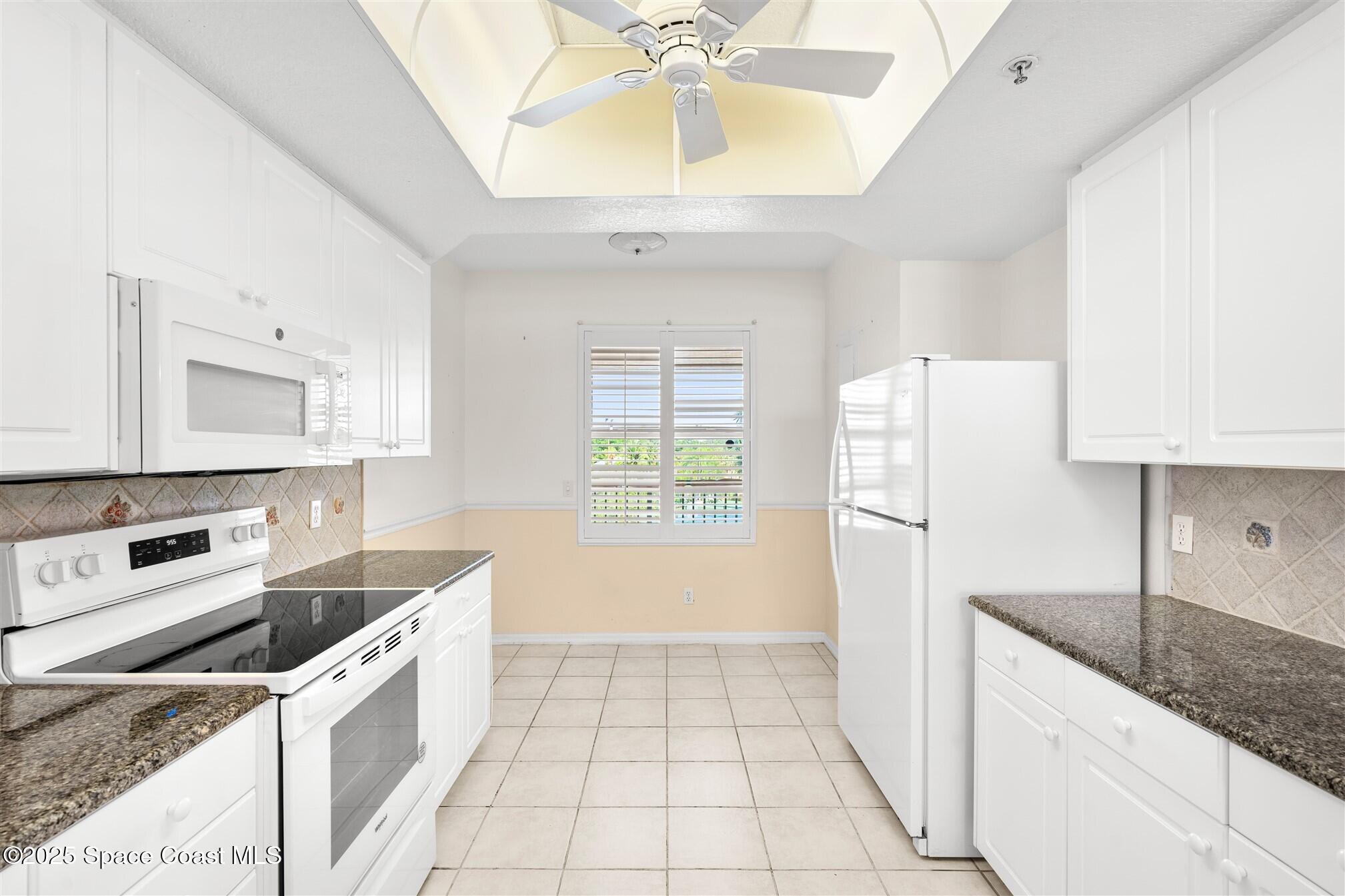 104 Riverside Drive, Unit 402 Cocoa, FL 32922 - Photo 10 of 41 a kitchen with a sink a refrigerator and cabinets