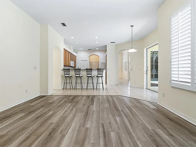 an empty room with wooden floor and window