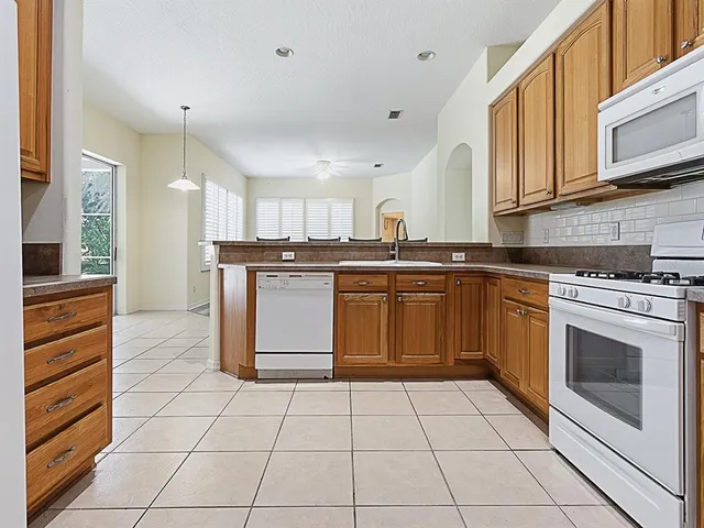 a kitchen with stainless steel appliances granite countertop a stove a sink and a refrigerator