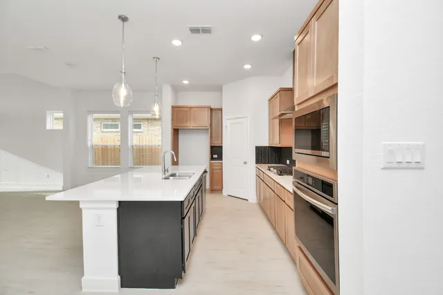 a kitchen with stainless steel appliances kitchen island granite countertop a sink and a stove