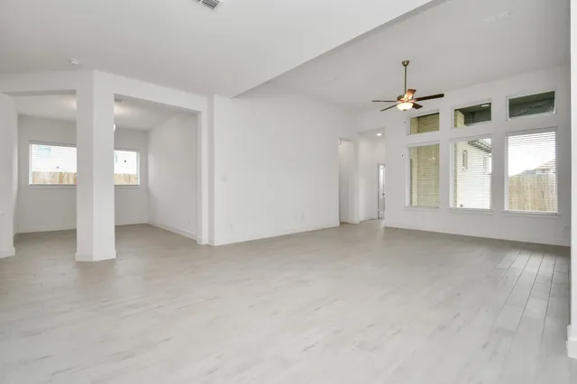 a view of a kitchen with a sink and dishwasher a refrigerator with white cabinets