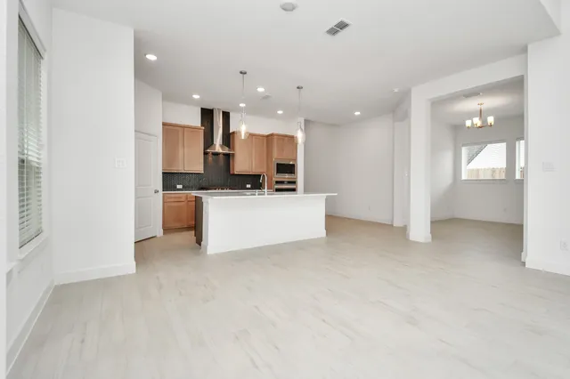 an empty room with windows and ceiling fan