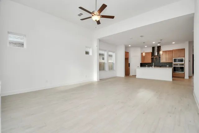 a view of a kitchen with refrigerator and wooden floor