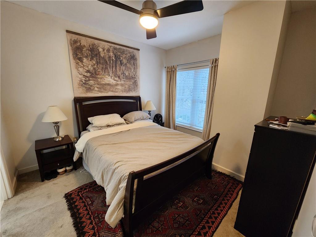 195 14th Street Northeast, Unit 304 Atlanta, GA 30309 - Photo 14 of 25 a bedroom with a bed and a lamp on the dresser