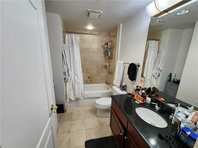 a view of hallway with walk in closet and wooden floor