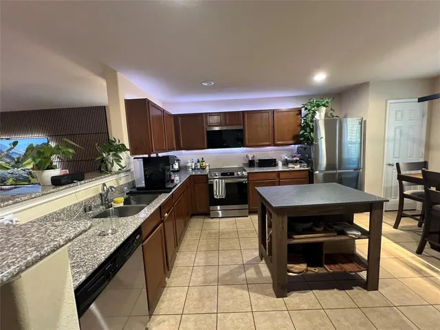 a kitchen with stainless steel appliances granite countertop a sink and a stove