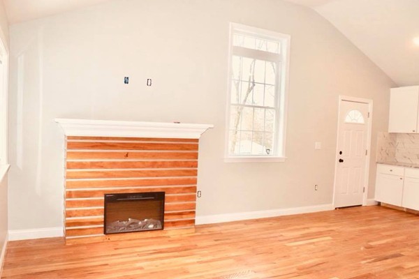 144 Salem Road Billerica, MA 01821 - Photo 4 of 16 a view of empty room with wooden floor and fireplace