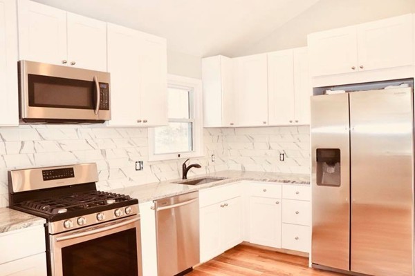 144 Salem Road Billerica, MA 01821 - Photo 5 of 16 a kitchen with stainless steel appliances white cabinets and a stove top oven