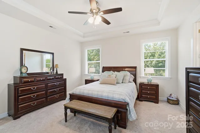 a bedroom with a bed and a flat tv screen on dresser