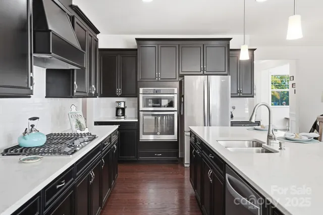 a kitchen with stainless steel appliances a sink stove and refrigerator