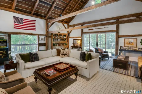 a living room with furniture a flat screen tv and a large window
