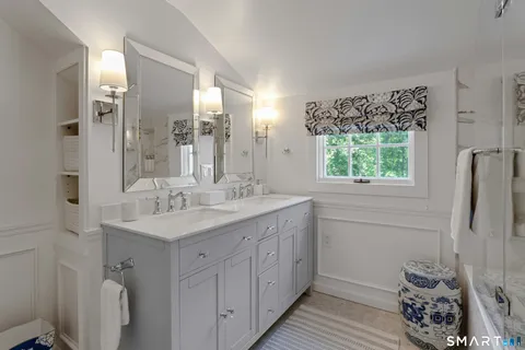 a bathroom with a double vanity sink toilet and a mirror