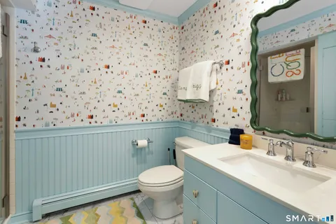 a bathroom with a toilet sink and mirror