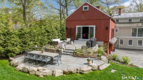 a view of a chair and table in backyard of the house