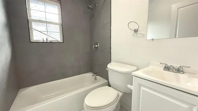 a white toilet sitting next to a bath tub