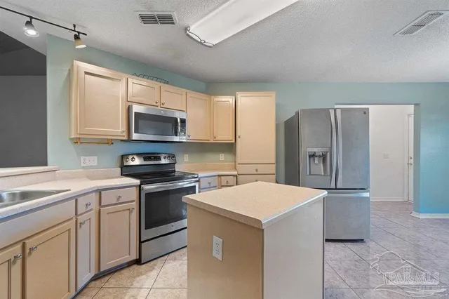 a kitchen with a sink a microwave a refrigerator and cabinets