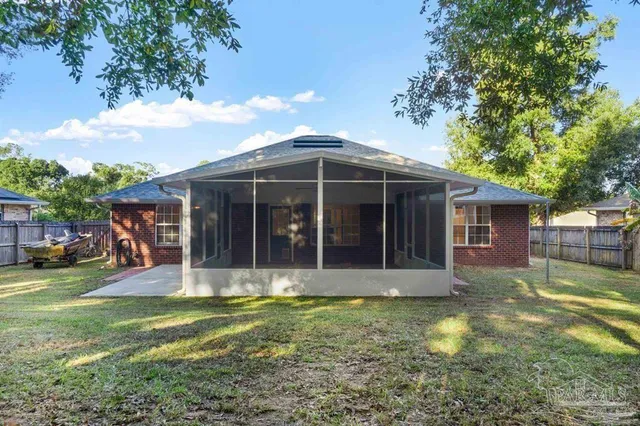 a view of a house with backyard garden and sitting area