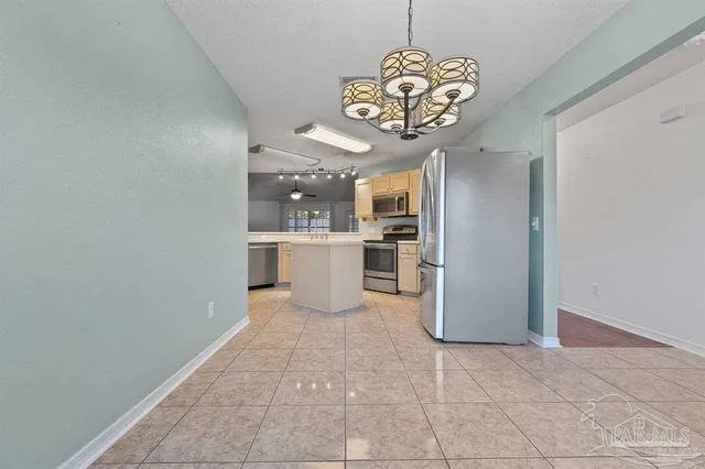 a view of a kitchen with a refrigerator and a stove top oven