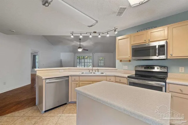 a kitchen with stainless steel appliances a stove microwave and sink