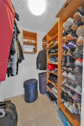 a view of walk in closet with clothes and shoes