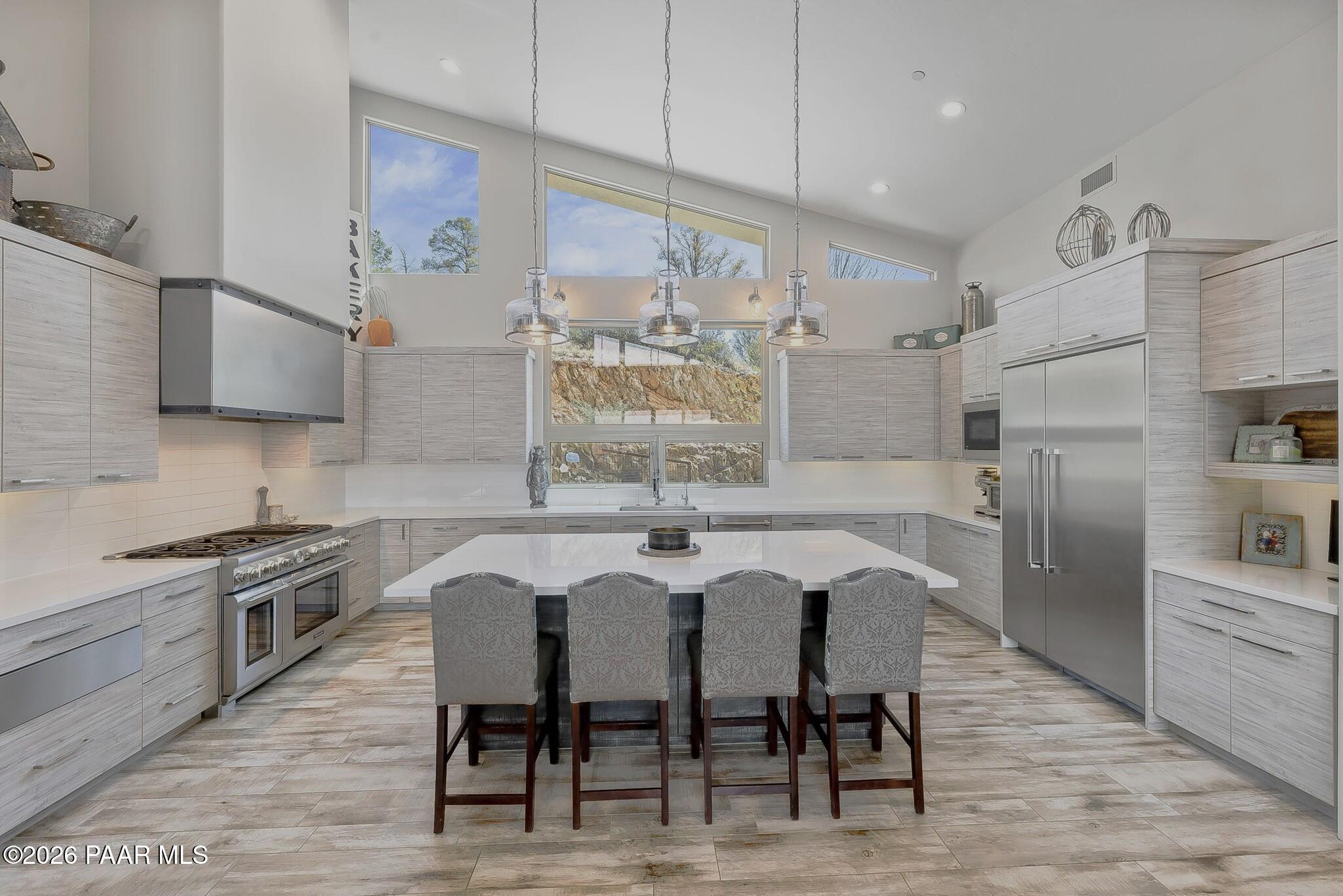 5245 West Three Forks Road Prescott, AZ 86305 - Photo 21 of 68 a kitchen with stainless steel appliances granite countertop a table chairs sink refrigerator and microwave