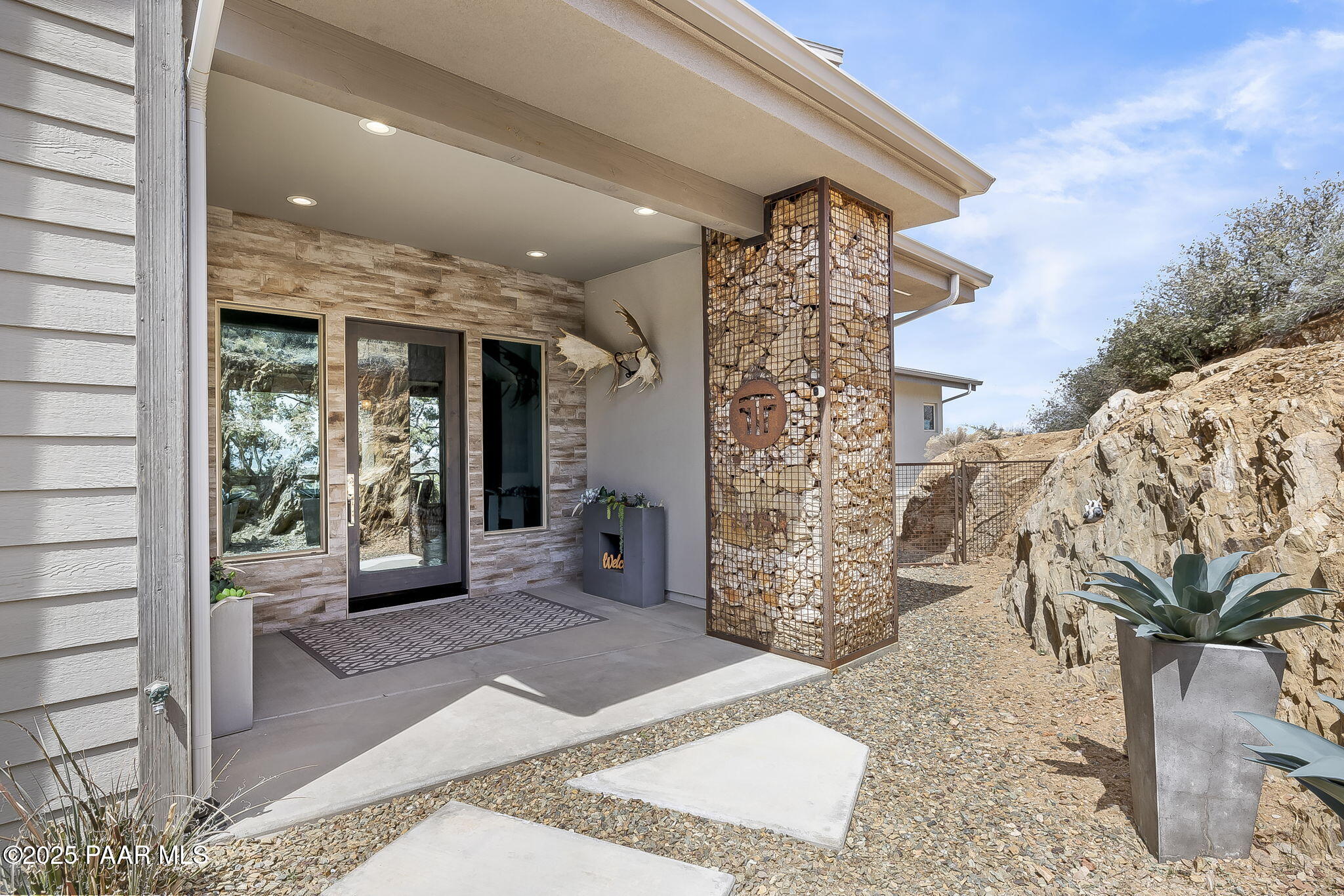 5245 West Three Forks Road Prescott, AZ 86305 - Photo 6 of 68 a view of a porch with a floor to ceiling window and potted plants