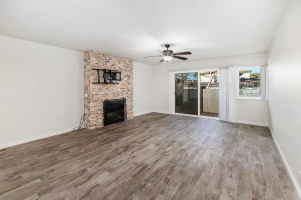 a view of empty room with wooden floor and fireplace
