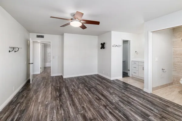 a view of a livingroom with wooden floor and a ceiling fan