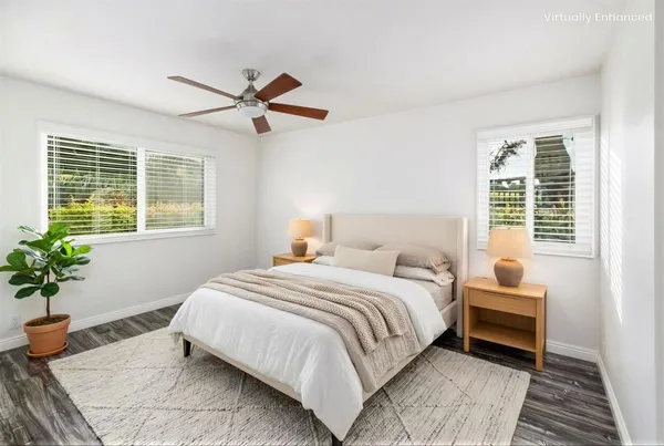a bedroom with a large bed chandelier and a window