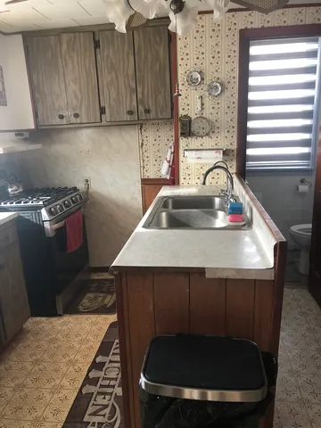 a kitchen with a sink a stove and a cabinets