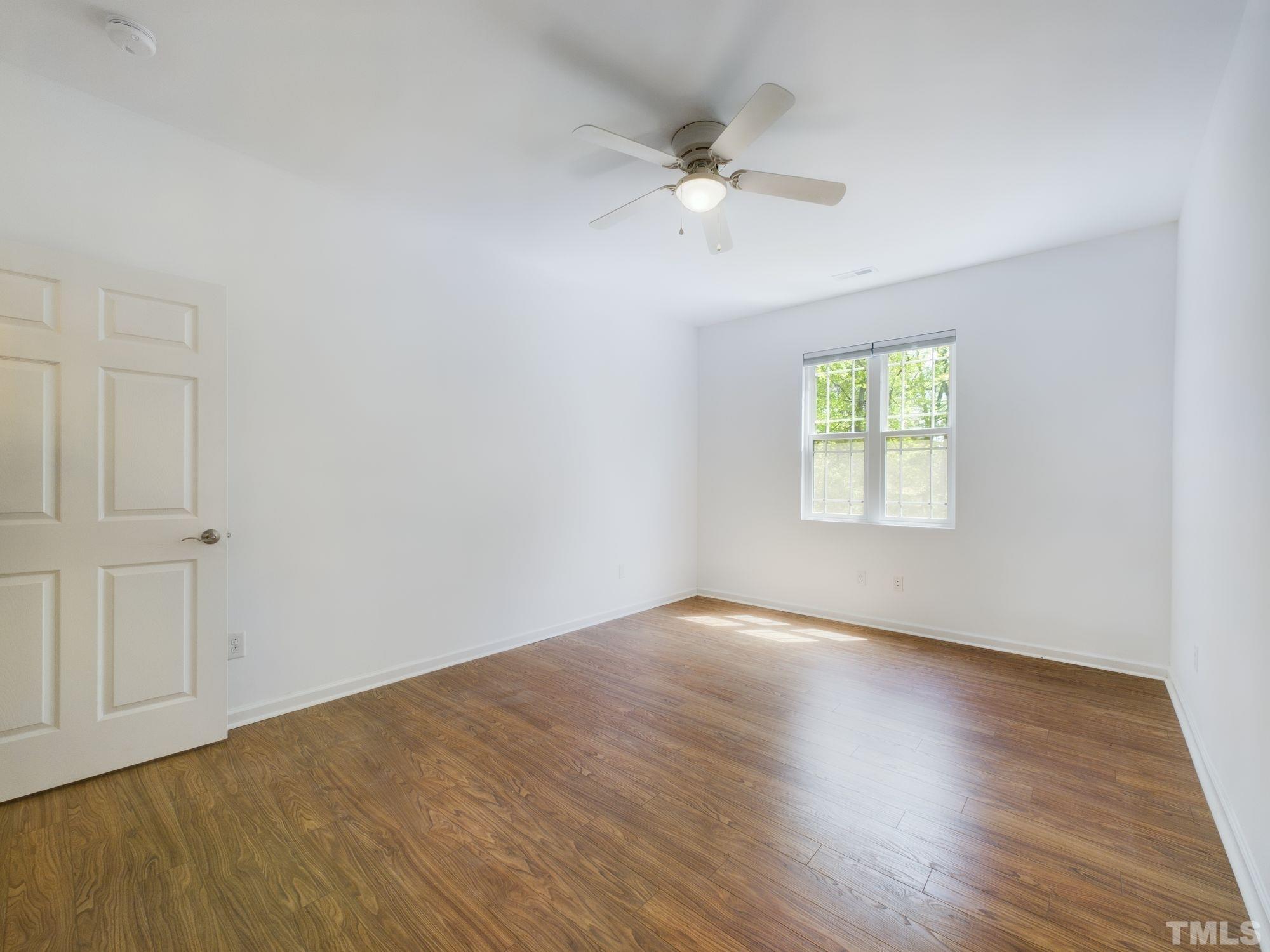 3321 High Gate Road Raleigh, NC 27603 - Photo 54 of 85 a view of an empty room with wooden floor and a window