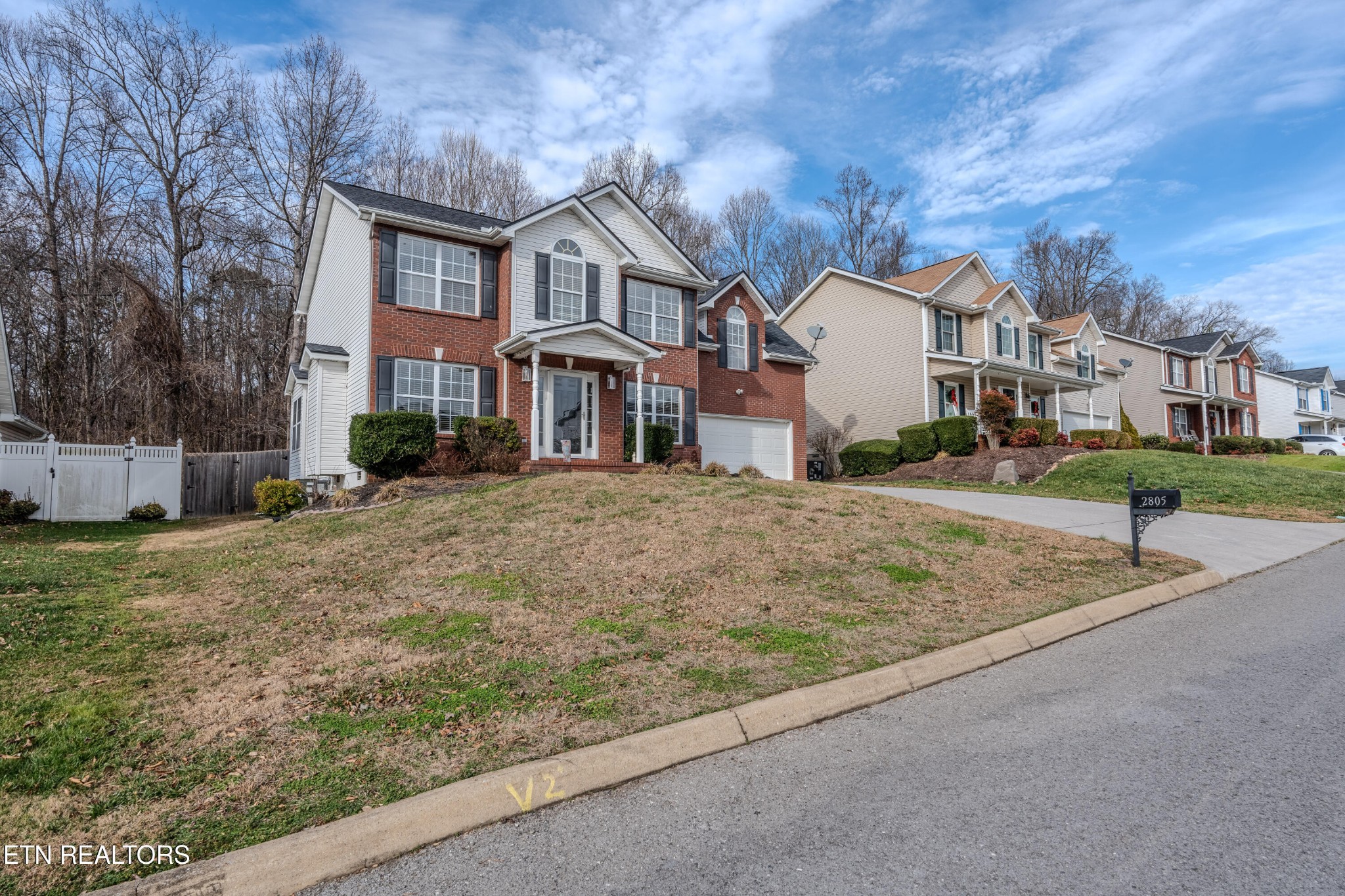 2805 Porch Swing Road Knoxville, TN 37938 - Photo 4 of 48 a view of a white house next to a yard with big trees