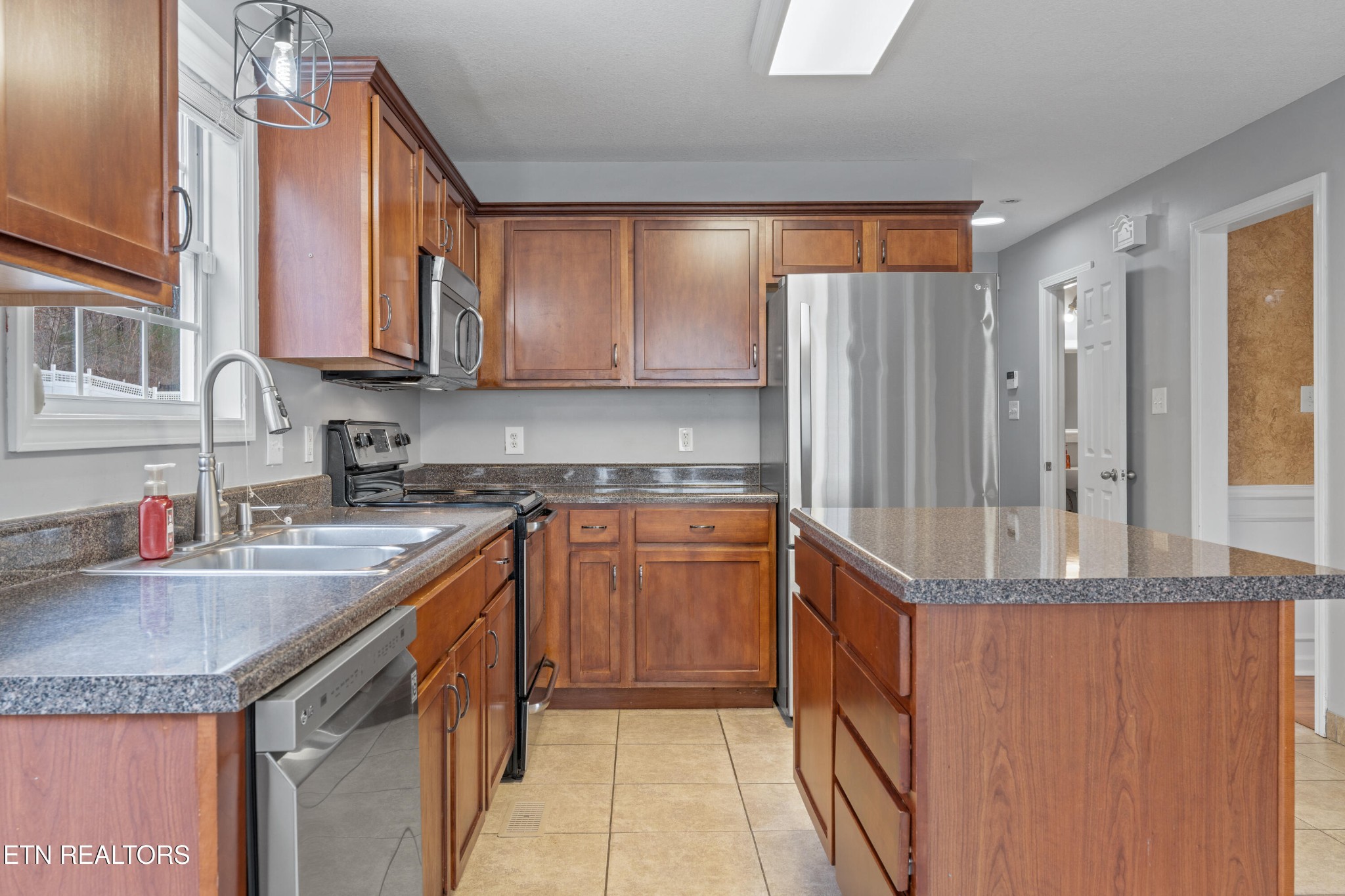 2805 Porch Swing Road Knoxville, TN 37938 - Photo 9 of 48 a kitchen with granite countertop a sink and a refrigerator