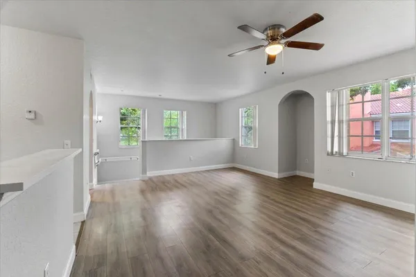 a view of an empty room with a window and wooden floor