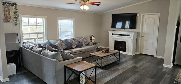 a living room with furniture a fireplace and a flat screen tv