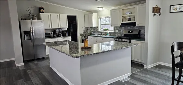 a kitchen with stainless steel appliances granite countertop a refrigerator a stove and a sink