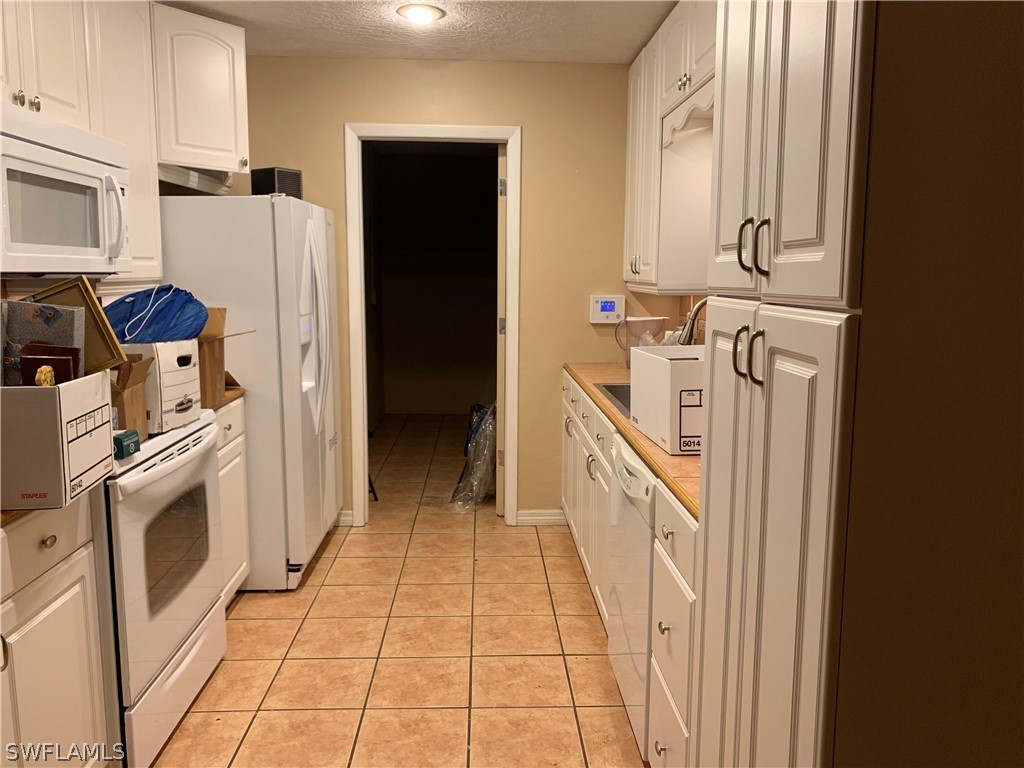 2219 Lily Road Fort Myers, FL 33905 - Photo 9 of 23 a kitchen with a refrigerator a stove a washer and dryer