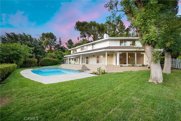 a view of a house with a yard and sitting area