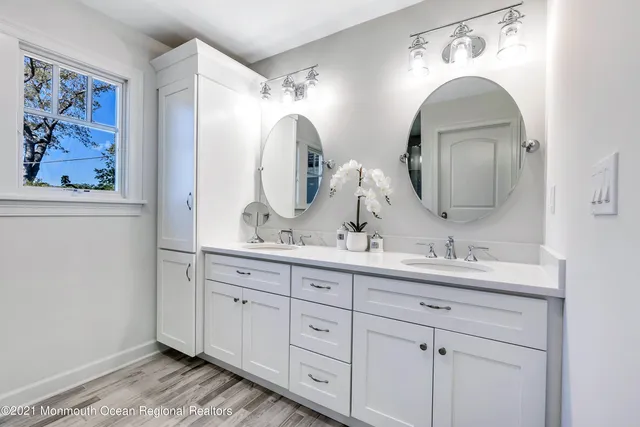 a bathroom with double vanity sinks and a two mirror