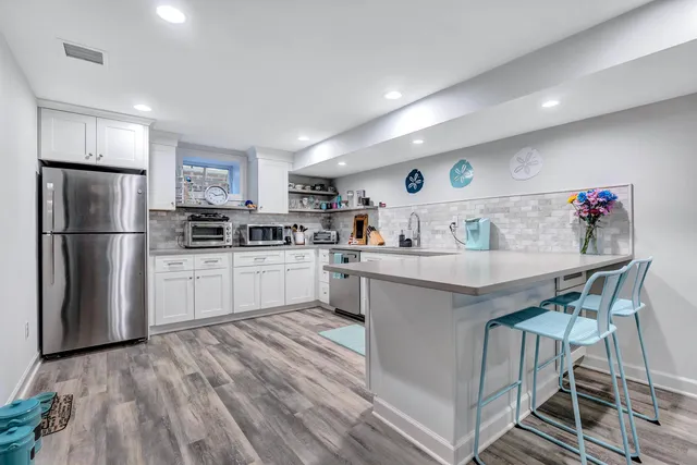 a kitchen with a sink a refrigerator and cabinets