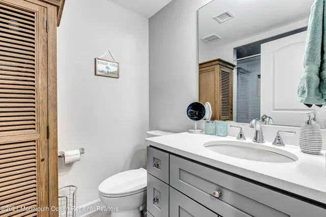 a bathroom with a granite countertop sink a toilet and a mirror