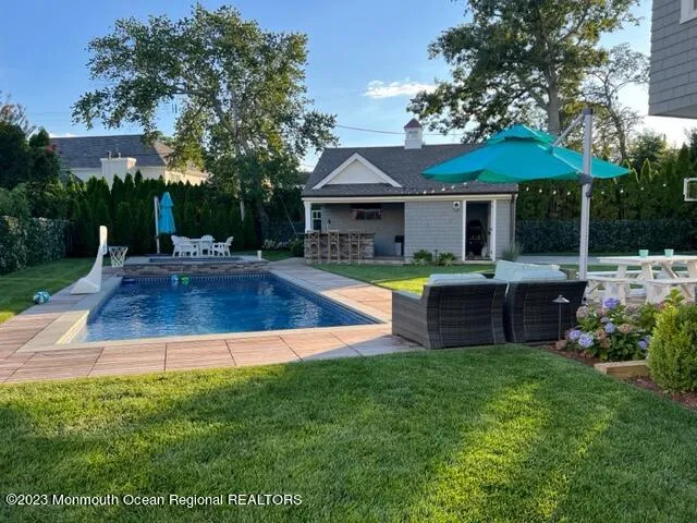 a view of a house with a swimming pool and sitting area