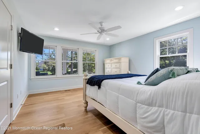 a bedroom with a large bed and a flat tv screen