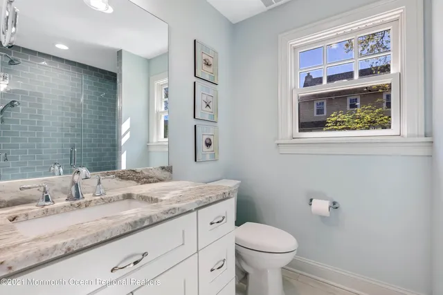 a bathroom with a granite countertop toilet sink and mirror