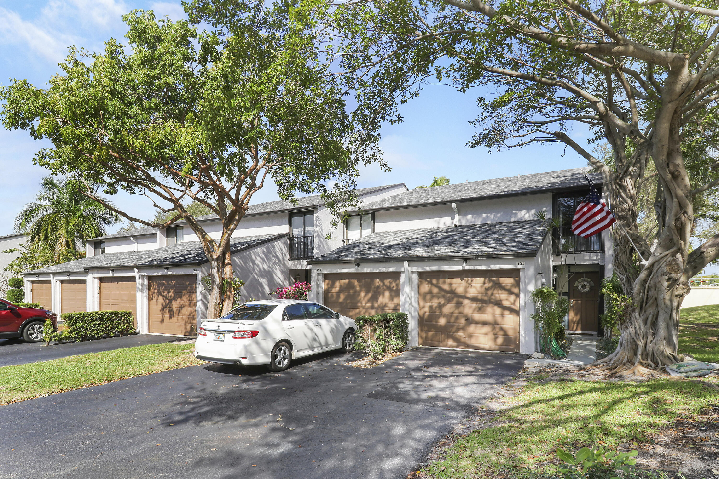 4801 Northwest 2nd Avenue, Unit 101 Boca Raton, FL 33431 - Photo 28 of 31 a white house that has a tree in front of it