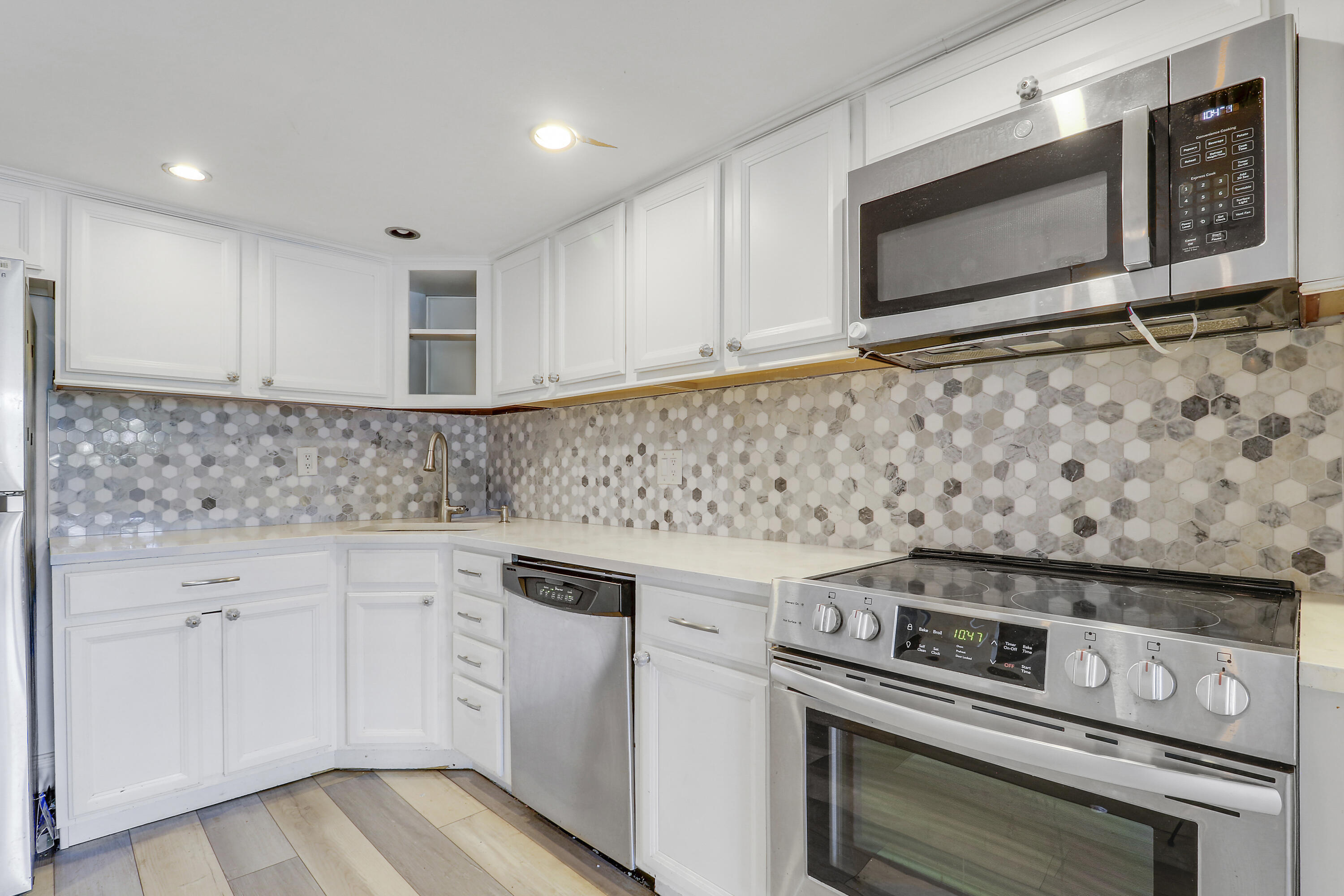4801 Northwest 2nd Avenue, Unit 101 Boca Raton, FL 33431 - Photo 31 of 31 a kitchen with granite countertop cabinets stove top oven and microwave