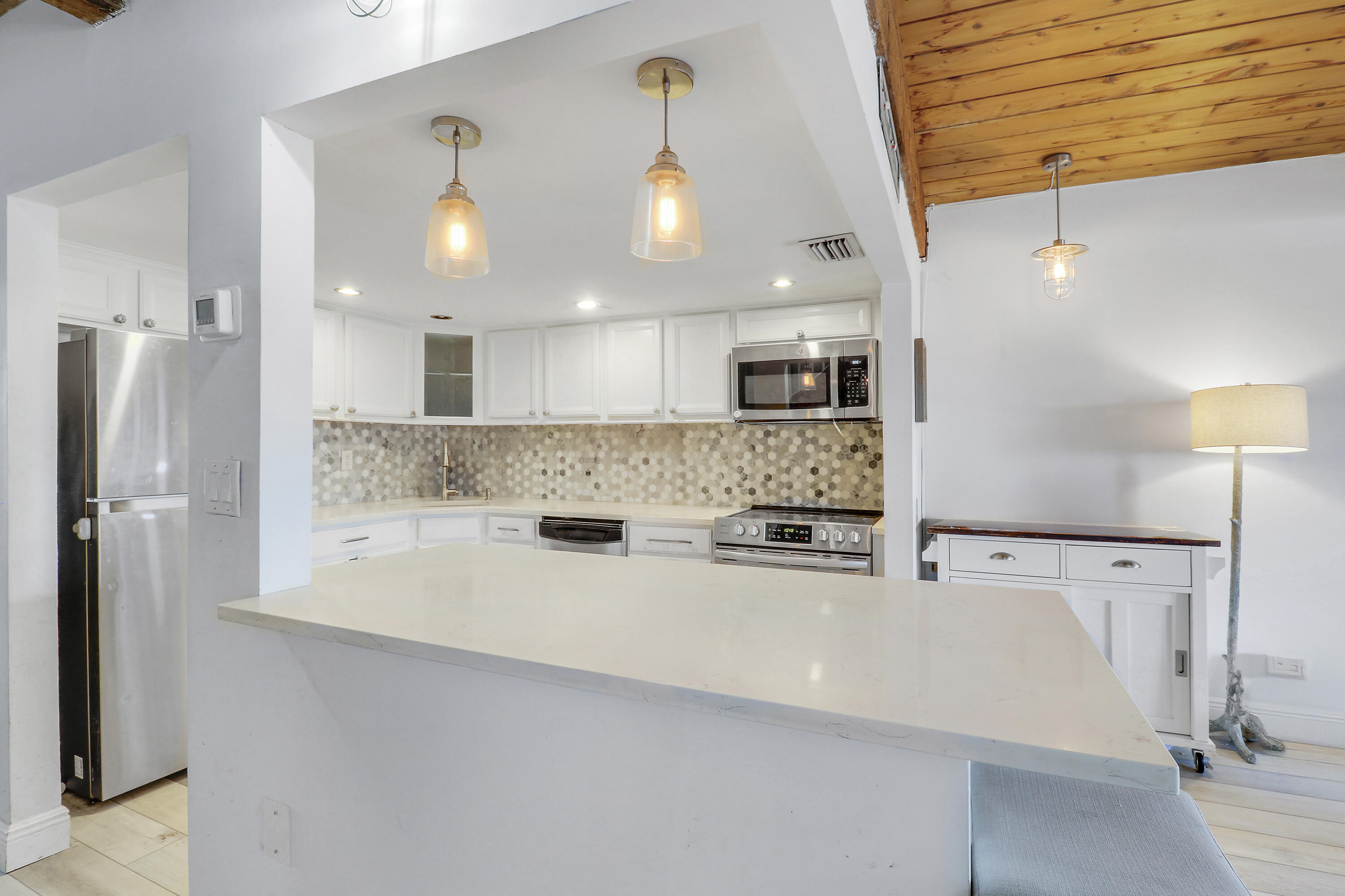 4801 Northwest 2nd Avenue, Unit 101 Boca Raton, FL 33431 - Photo 5 of 31 a large kitchen with stainless steel appliances a refrigerator and a stove top oven