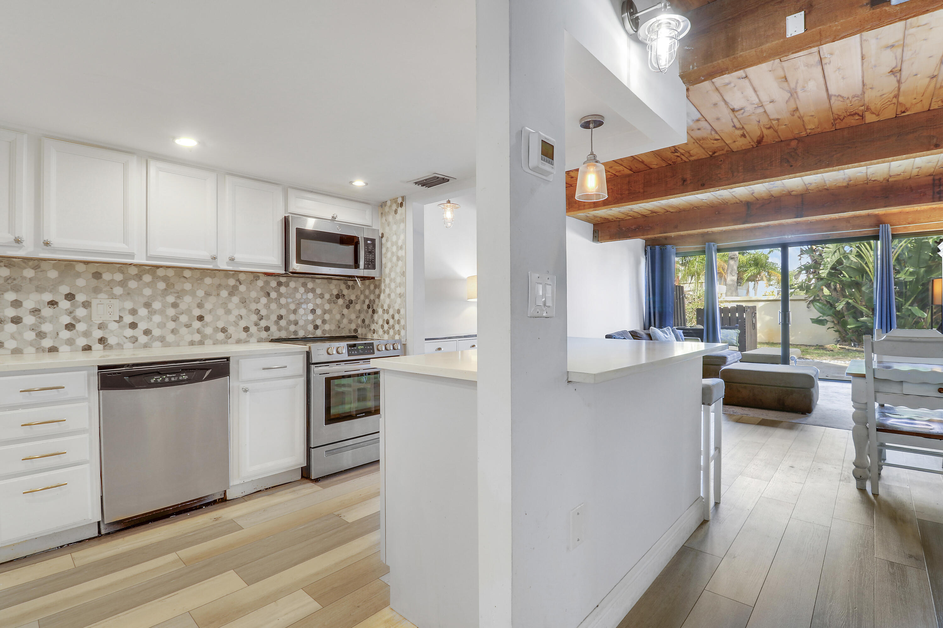 4801 Northwest 2nd Avenue, Unit 101 Boca Raton, FL 33431 - Photo 7 of 31 a kitchen with kitchen island granite countertop lots of counter top space and stainless steel appliances