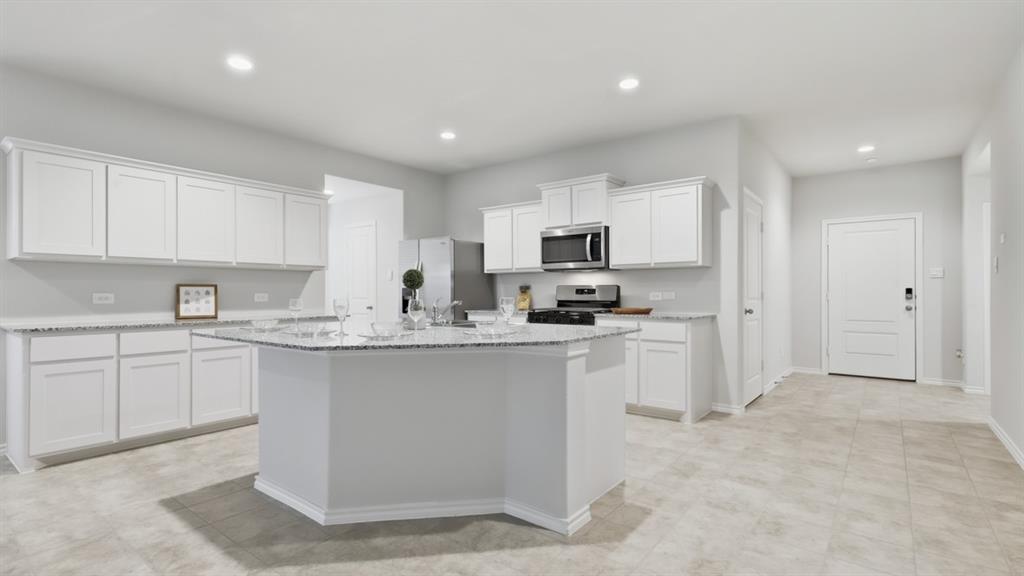 a kitchen with cabinets appliances a sink and a counter top space